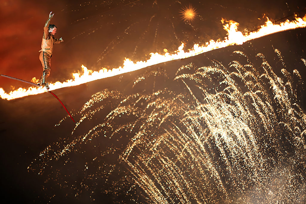 Jade performs on his fire high-wire at the festival of speed in England for Cirque Bijou. a one-of-a-kind stunt.